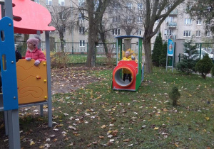 Dzieci korzystają z nowych zabawek na przedszkolnym placu zabaw.