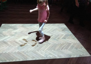 Dziewczynka na magicznym dywanie idzie po śladach jakiegoś zwierzątka.