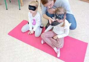 Dzieci, z zasłoniętymi oczami, próbują rozpoznać tajemniczy produkt za pomocą węchu.
