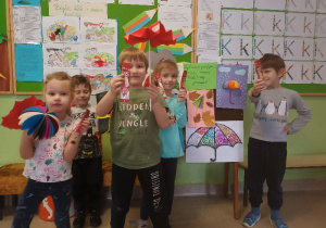 Dzieci pokazują swoje pomysły zrobienia parasola.