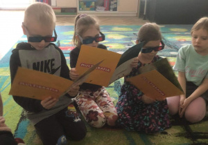 Dzieci oglądają plansze w okularach 3D.