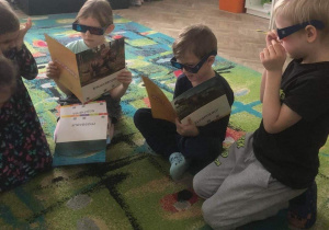 Dzieci oglądają plansze w okularach 3D.