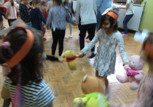 Dzieci tańczą w małych grupach ze swoimi pluszowymi misiami.