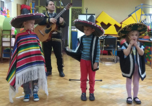 Dzieci przymierzają elementy meksykańskiego stroju: sombrero i ponczo.