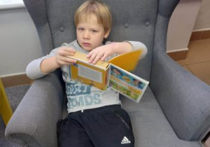 Chłopiec przegląda książkę.