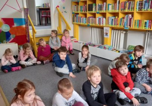 Dzieci słuchają opowiadania pani bibliotekarki.
