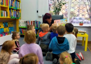 Dzieci oglądają ilustracje książki.