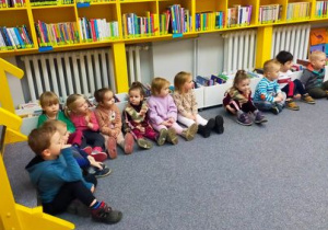 Dzieci słuchają bajki czytanej przez panią Ewę.
