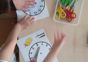 Dzieci kolorują przed wycięciem kukułki i tarcze zegarów.