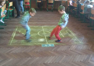 Chłopcy grają w piłkę nożną na magicznym dywanie.