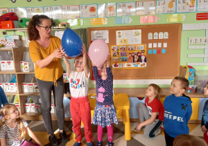 Dzieci sprawdzają, który balon spadnie szybciej, czyli który jest cięższy.