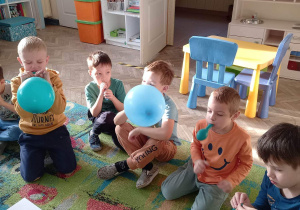 Dzieci dmuchają balony.