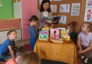 Mama Krzysia czyta bajkę dzieciom z grupy niebieskiej.