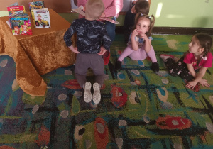 Dzieci z zaciekawieniem słuchają bajki czytanej przez mamę Rafałka.