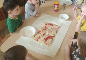 Dzieci smarują ciasto ketchupem