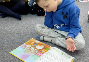 Chłopiec czyta książkę.
