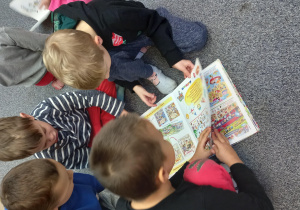 Chłopcy przeglądają książkę.
