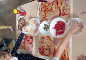 Dzieci przygotowują pizzę.