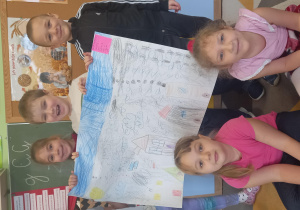 Grupa dzieci prezentuje swój plakat.