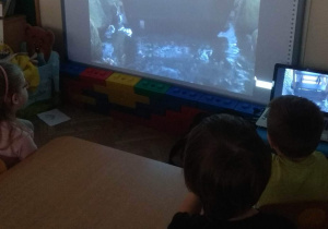 Dzieci oglądają koło młyńskie napędzane wodą.