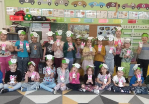 Dzieci prezentują swoje prace: opaski na głowę - baranki i króliczki z papierowych kubeczków.