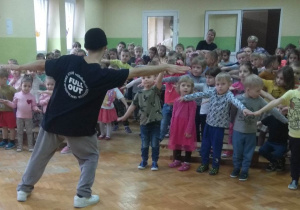 Tancerz uczy dzieci układu tanecznego.