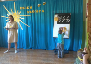 Chłopiec odkrywa kolejny element z zakrytego obrazka (zaćmienie Słońca)..