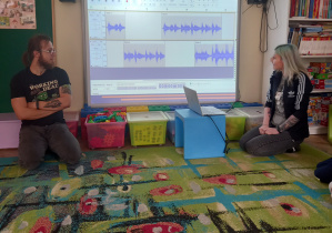 Rodzice Weroniki prezentują program komputerowy na tablicy multimedialnej.