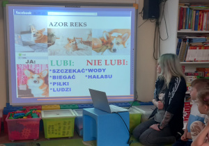Mama Weroniki zapoznaje dzieci z prezentacją na tablicy multimedialnej.