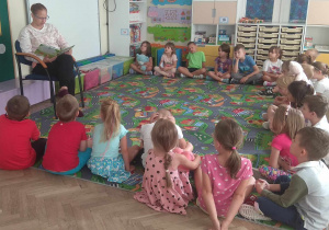 Dzieci słuchają bajki czytanej prze mamę Anastazji.