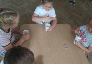 Dzieci spożywają własnoręcznie przygotowany jogurt.