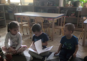 Dzieci oglądają książkę.