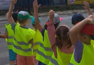 Dzieci zanim przejdą na drugą stronę ulicy patrzą w prawą stronę i unoszą rękę na sygnał przechodzenia.