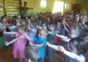 Dzieci biorą udział w zabawie ruchowej przy piosence.
