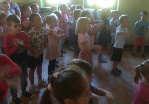 Dzieci biorą udział w zabawie ruchowej przy piosence.