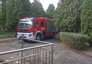Wóz strażacki wjeżdża na teren przedszkola.
