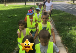 Dzieci idą po chodniku.