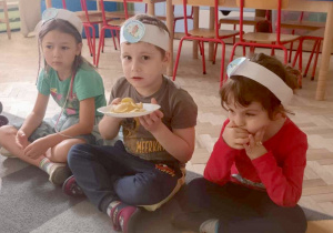 Dzieci trzymają talerzyk z chipsami.