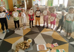 Dzieci prezentują napis "Dzień ziemniaka".
