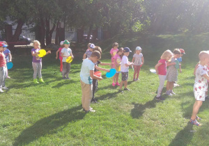 Dzieci ćwiczą w ogrodzie przedszkolnym.