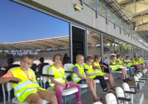 Dzieci siedzą i oglądają stadion ze strefy VIP.