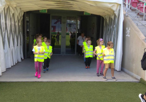 Dzieci wychodzą z tunelu na stadion.