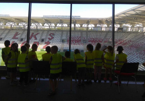 Dzieci oglądają stadion z loży prasowej.