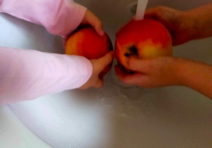 Dzieci myją owoce.
