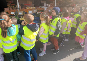 Dzieci oglądaja owoce i warzywa w sklepie.