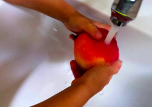 Dzieci myją owoce.