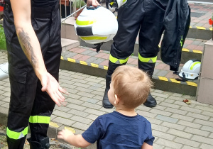 Chłopiec wita się ze strażakiem.