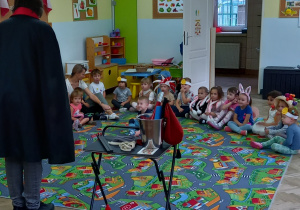 Dzieci oglądają pokaz magika.