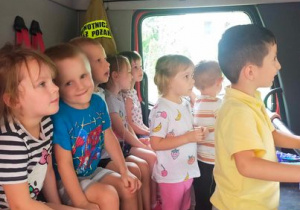 Dzieci w kabinie wozu strażackiego.