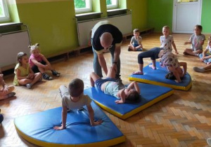 Dzieci z najstarszych grup wykonują ćwiczenia gimnastyczne.